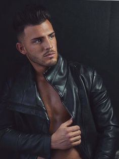a shirtless man wearing a black leather jacket