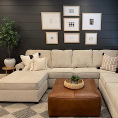 a couch and ottoman in a room with pictures on the wall behind it, along with other furniture