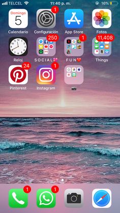 an iphone with icons on the screen and in the background, there is a sunset