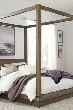 a four poster bed in a bedroom with white walls and carpeted flooring on the side