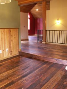 an empty room with wooden floors and railings