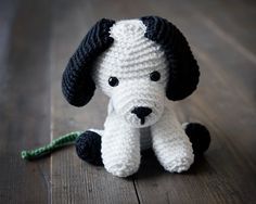 a crocheted dog sitting on top of a wooden floor next to a green string