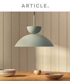 a table with two bowls and a light fixture on it that reads article