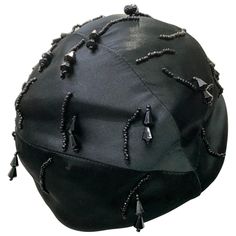 1950 Miss Dior black silk satin cloche style hat features delicate black jet beading and jeweled drops . The seaming and construction in design allows for a form fit on the crown . This simple yet chic design is reminiscent of this iconic fashion house. The modernized cloche-style hat has a wire frame giving it shape when worn slightly tilted to the back. Fits up to a size medium crown. Black Felt Hat, Dior Hat, Creative Accessories, Black Jet, Vintage Dior, Designer Hats, Iconic Fashion, Miss Dior