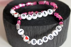 two bracelets that say i love you and the word barbie on them are made with swarong beads
