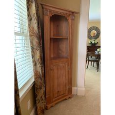 a tall wooden cabinet sitting in the corner of a room