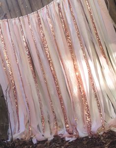 pink and gold sequins hanging from a wooden fence