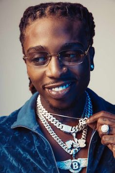 a man with glasses and jewelry on his neck