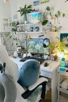 a computer desk with two monitors on top of it and plants in the back ground