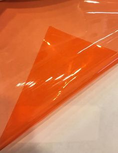 an orange plastic triangle sitting on top of a table