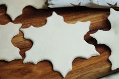 some cut out cookies sitting on top of a wooden cutting board