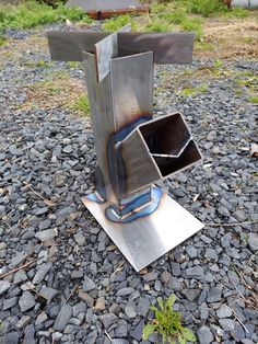 a metal object sitting on top of a pile of rocks