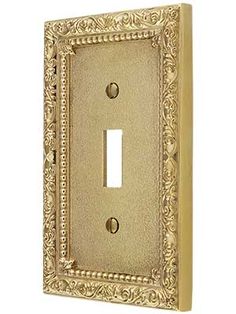 an ornate light switch plate cover in gold