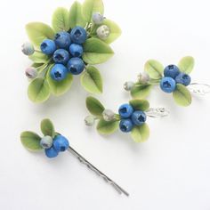 blueberries and leaves are attached to the hair pins