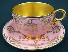 a pink and gold tea cup on a saucer