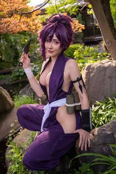 a woman with purple hair is holding a knife in her hand and posing for the camera