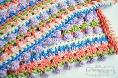 a crocheted dishcloth with multicolored yarns on the bottom and sides