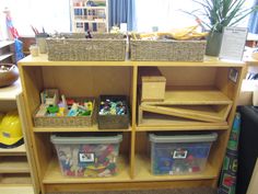 a wooden shelf filled with plastic containers and bins