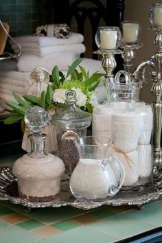 a table topped with lots of white towels and vases
