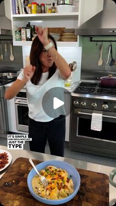 a woman standing in front of a bowl of food on top of a kitchen counter