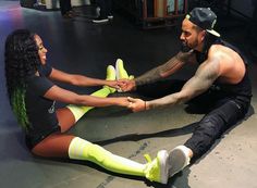 a man and woman sitting on the floor holding hands