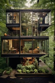 a modern house in the woods with lots of windows and balconies on each floor