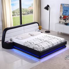 a bed that has some lights on the side of it in front of a window