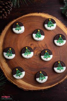 cookies decorated to look like a christmas tree on a wooden platter with pine cones