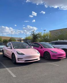 two pink cars parked in a parking lot next to each other on a sunny day