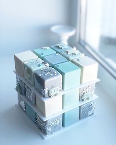 a stack of small boxes sitting on top of a table next to a window sill