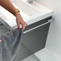 a person holding a towel in front of a sink