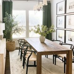 a dining room table with chairs and pictures on the wall