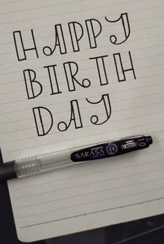 a notepad with the words happy birth day written on it next to a pen