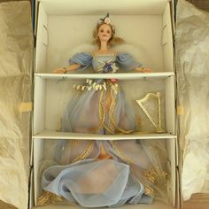 a doll in a box that is sitting on top of the other boxes and it looks like she's wearing a princess costume