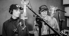 two young men wearing headphones in front of microphones