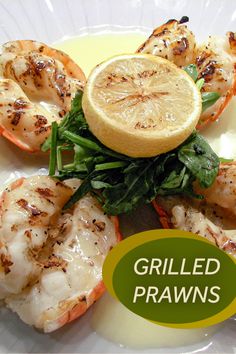 grilled prawns on a plate with lemon wedges and garnish