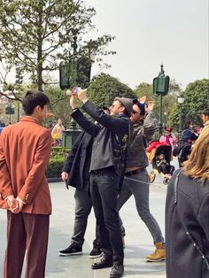 two men are taking pictures with their cell phones while others look on in the background