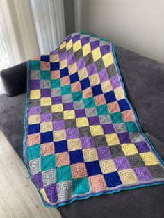 a crocheted blanket is sitting on a couch