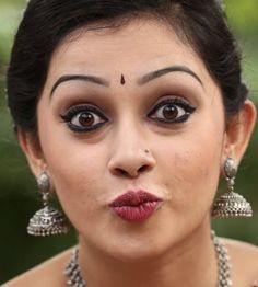 a close up of a woman with makeup on her face and wearing jewelry around her neck