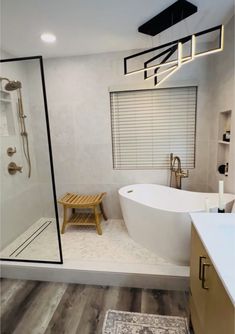 a bathroom with a large white tub sitting next to a walk in shower