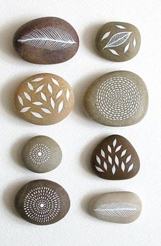 six rocks with different designs on them sitting next to each other in the shape of leaves