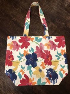 a flowered bag sitting on top of a wooden table