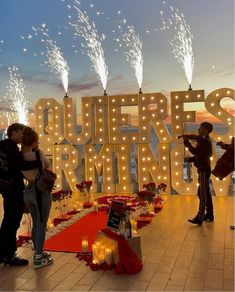 two people standing in front of a sign that says queens brimming with fireworks