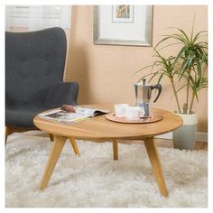 a chair and table in a living room with a potted plant on the coffee table