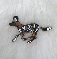 a brown and white dog with black spots on it's face is laying down