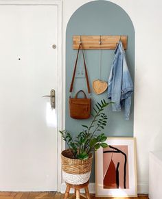 a potted plant sitting on top of a wooden stand next to a white door