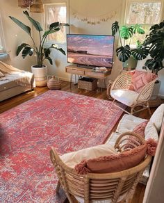 a living room filled with furniture and a large rug on top of a hard wood floor