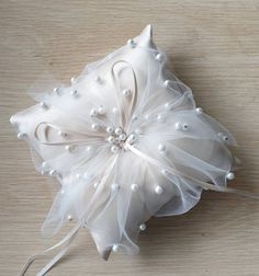 a white flower with pearls on it sitting on a table