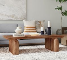 a living room with a couch, table and vases on the coffee table in front of it