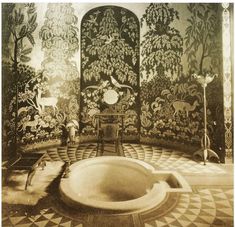 an old photo of a bathtub in the middle of a room with floral wallpaper